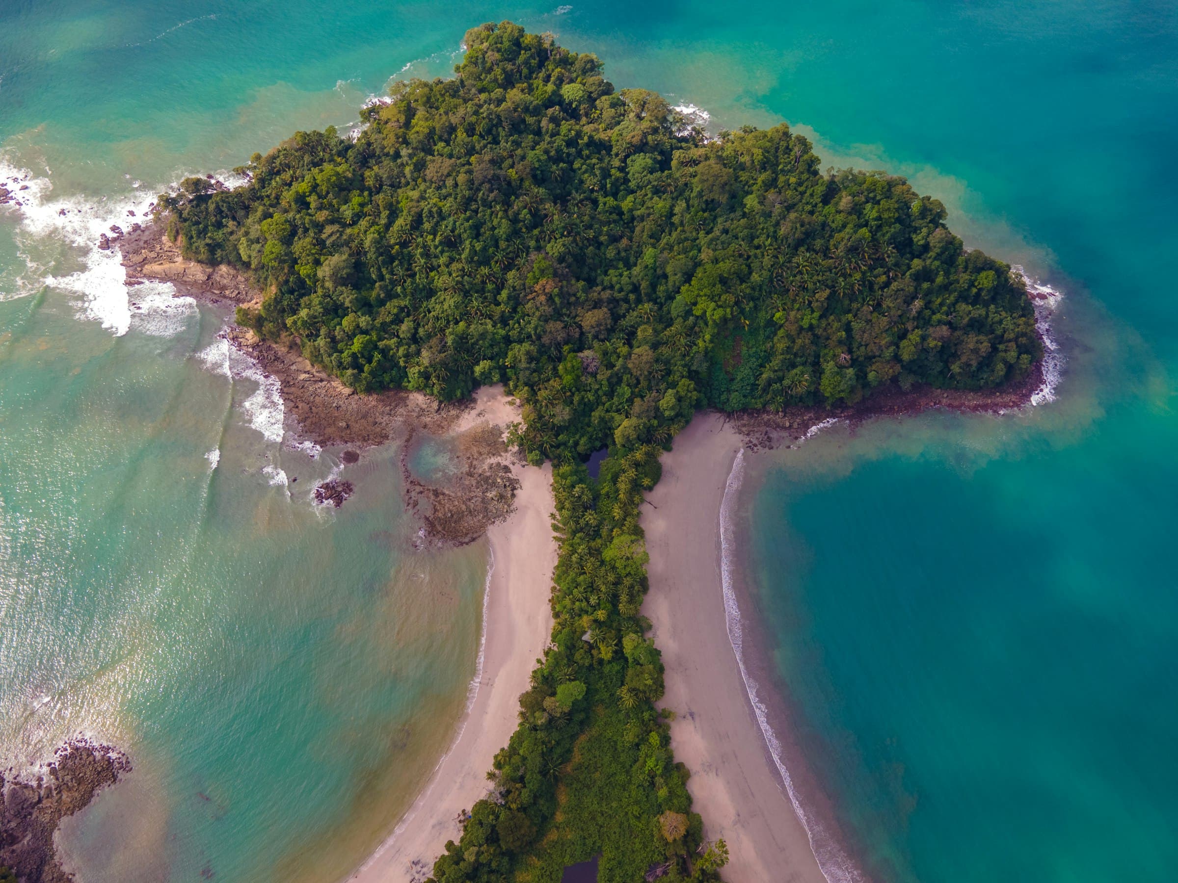 Aerial view of Punta Catedral in Manuel Antonio, with the strip of sand between two turquoise bays